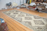 Distressed vintage Oushak runner with staggered medallions in soft ivory and charcoal.