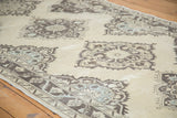Distressed Oushak runner's staggered medallions in soft ivory, charcoal, and slate blue tones.