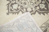 Distressed Oushak runner with ivory and charcoal medallion pattern and visible hand-knotted foundation.