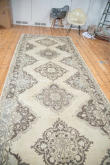 Distressed texture and time-softened tones of charcoal, ivory, and soft blue medallion detail.
