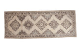 Distressed Turkish Oushak runner, faded ivory, charcoal, and muted blue staggered medallions.
