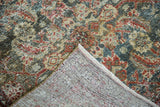 Distressed herati pattern in green, gold, and red, with visible hand-knotted Malayer foundation.