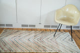 Distressed Oushak rug with faded red, ivory, and charcoal abstract staggered diamond pattern.