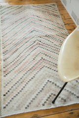 Distressed vintage Oushak rug showing abstract staggered diamond pattern in faded colors.