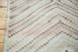 Textural distressed Oushak rug with modern staggered diamond pattern: faded red, ivory, charcoal.