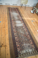 Antique Caucasian runner featuring repeating diminutive medallions, Lehla-Abassi border, and localized wear.