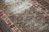 Distressed antique Caucasian rug detail: geometric medallions, Lehla-Abassi floral border, camel and red.