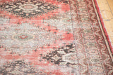 Distressed Oushak runner featuring faded cinnabar, beige, and charcoal tribal motifs.