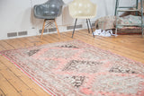 Distressed Oushak runner with geometric patterns in faded cinnabar and charcoal.