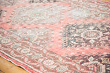 Distressed Oushak runner with faded cinnabar, charcoal, and beige geometric motifs.