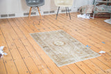 Distressed Turkish Oushak rug, central medallion, spiral tendrils, geometric floral border.