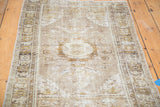 Distressed Oushak rug, angled view of geometric border with faded beige and grey tones.