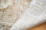 Folded Distressed Oushak rug showing faded geometric floral pile and hand-knotted foundation.