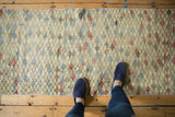 Distressed geometric diamond pattern on a vintage Oushak runner with varied color fills.