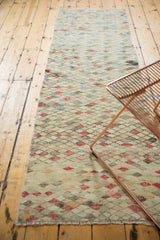 Close-up of distressed Oushak runner showing unique diamond pattern, varied color fills, and fringe.