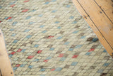 Distressed Oushak runner, close-up of unpredictable diamond motif in muted ivory, apricot, and blue.