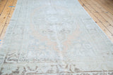 Distressed Oushak rug with soft abrashes, muted peach field, and geometric border.