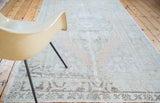 Distressed Oushak carpet with faded peach, blue tones, and geometric border detail.
