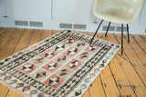 Faded cochineal red, ivory, charcoal geometric guls and diamond motifs on distressed Turkish Kilim.