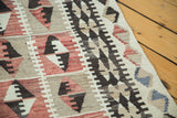 Distressed Turkish Kilim flatweave close-up; faded cochineal red, ivory, charcoal geometric guls.