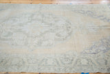 Hand-knotted distressed Oushak carpet with soft peach field and faded blue motifs.