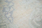 Vintage distressed Oushak rug pile with faded peach and muted royal blue tones.