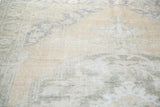 Close-up of distressed texture on the peach and faded blue Oushak rug.