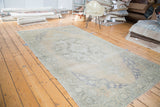 Decorative distressed texture featuring faded royal blue spandrels on an Oushak rug.