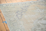 Faded peach and muted blue distressed Oushak carpet pile with soft texture.
