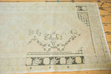 Distressed Oushak runner, charcoal geometric border, faded field motifs, and fringe.