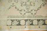 Distressed Oushak runner detail with ivory, charcoal, saffron zigzag and floral cross-section border.
