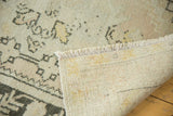 Distressed vintage Oushak runner revealing textured ivory pile, faded patterns, and woven back.