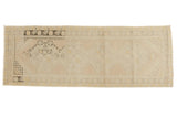 Distressed Oushak runner with faded medallions, geometric motifs in apricot, ivory, and charcoal tones.