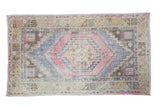 Distressed Turkish Oushak rug with faded cinnabar field, gold medallion, and geometric motifs.