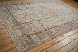 Distressed Oushak carpet with faded light rose and charcoal ornate patterns.