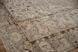 Distressed vintage Oushak rug corner showing light rose spandrel and cloudbands.