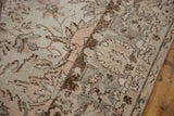Distressed Oushak rug pile with faded rose, ivory, brown, and grey curvilinear patterns.