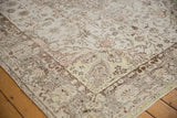 Distressed Oushak carpet corner, with faded ivory and charcoal floral motifs, highlighting a pale lime green spandrel.