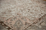 Light rose corner spandrel and distressed ivory floral patterns on an Oushak carpet.