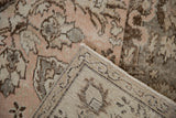 Distressed Oushak rug close-up: ornate light rose pile and hand-knotted foundation.