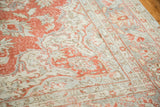 Distressed texture of a vintage Oushak rug with faded cranberry and soft grey floral designs.