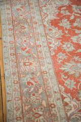 Distressed Oushak rug showing faded cranberry red field and light grey border patterns.
