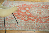 Distressed vintage Oushak rug with faded cranberry field and dark grey floral border.