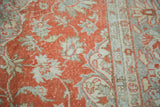 Distressed Oushak pile texture with faded cranberry field and grey botanical motifs.