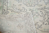 Hand-knotted foundation and faded ivory, green, charcoal pattern of distressed Oushak rug.