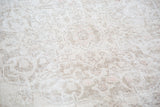 Hand-knotted Oushak rug pile with faded curvilinear patterns in beige and soft pastels.