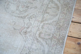 Hand-knotted texture and subtle pastel plant motifs on the vintage Oushak carpet edge.