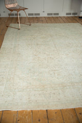 Vintage Oushak rug end showing its fringe, detailed border, and soft celadon floral vines.