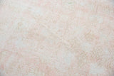Distressed Oushak rug texture with blush rose, ivory, and blanched light grey faded floral design.