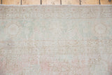 Distressed Oushak carpet with soft blush, ivory, and blanched grey floral pattern.
